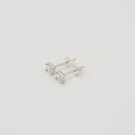 Rhodium-plated sterling silver stud earrings with emerald-cut clear cubic zirconia stones on a light background