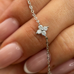 hodium-plated sterling silver bracelet with a four-petal cubic zirconia flower centerpiece