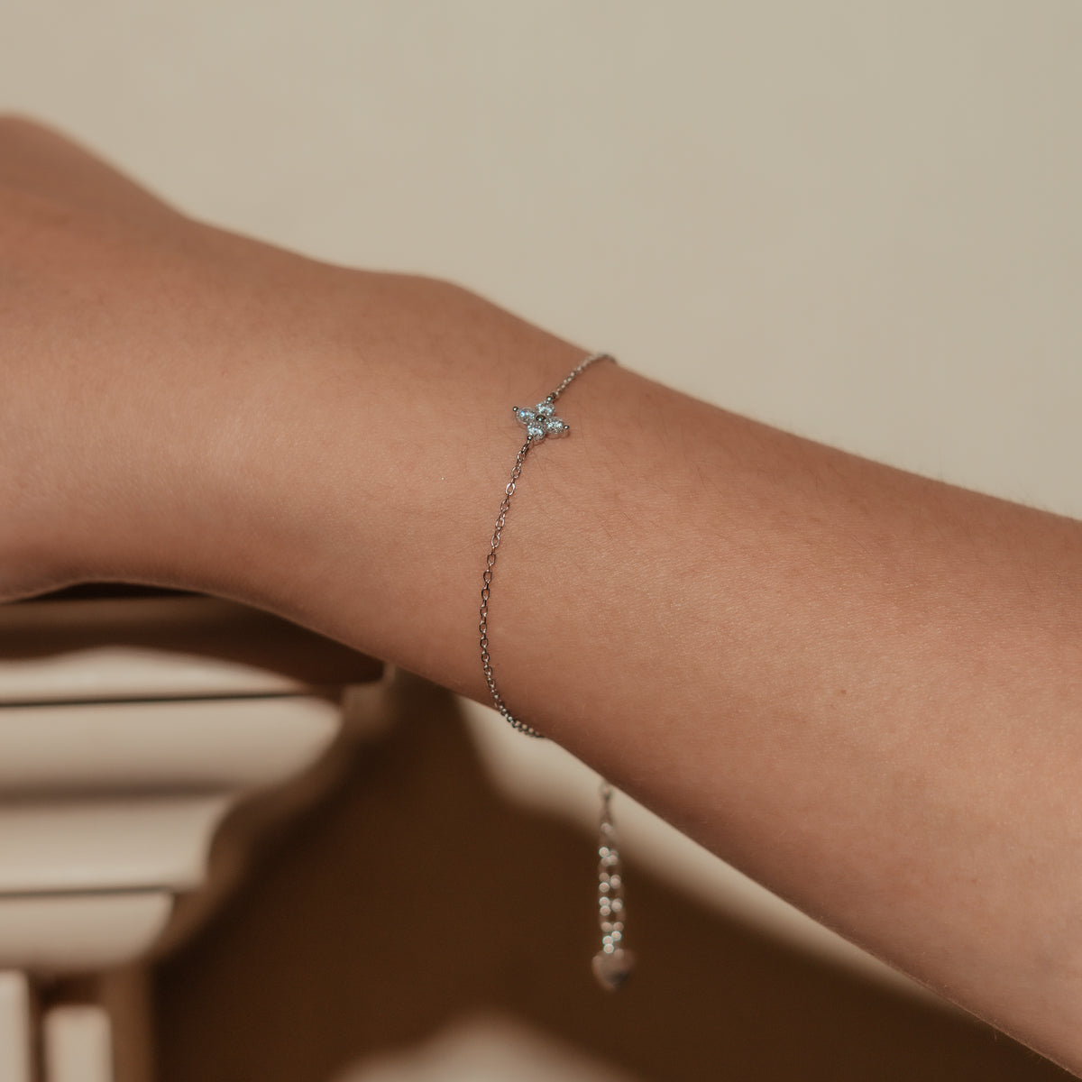 Rhodium-plated sterling silver bracelet with a four-petal cubic zirconia flower centerpiece worn on the wrist