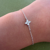 Rhodium-plated sterling silver bracelet with a four-petal cubic zirconia flower centerpiece worn on the wrist