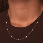 Rhodium-plated sterling silver necklace with delicate cubic zirconia flower details worn on the neck