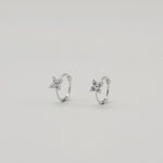 Rhodium-plated sterling silver hoop earrings with four-petal cubic zirconia flower details