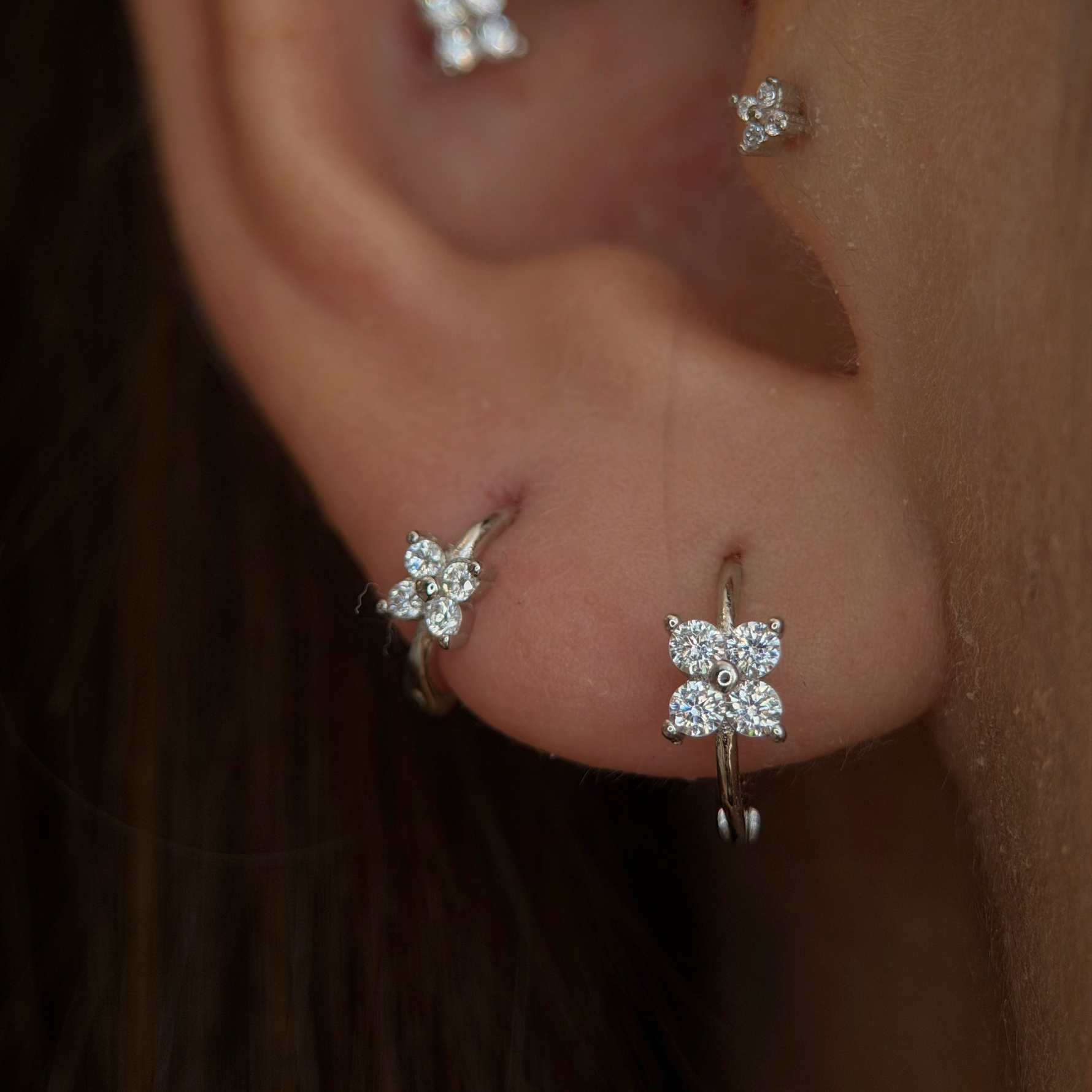 Rhodium-plated sterling silver hoop earrings with four-petal cubic zirconia flower details