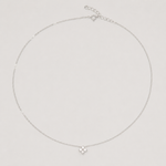 Rhodium-plated sterling silver necklace with a small four-petal cubic zirconia pendant on a light background