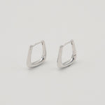 Rhodium-plated sterling silver geometric hoop earrings with a polished finish on a light background