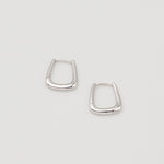 Rhodium-plated sterling silver geometric hoop earrings with a polished finish on a light background
