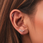Rhodium-plated sterling silver stud earrings with marquise and round cubic zirconia leaf details worn on ear
