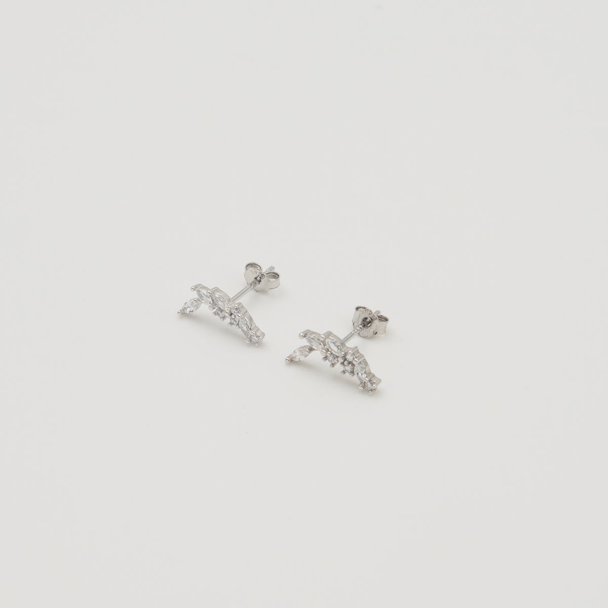 Rhodium-plated sterling silver stud earrings with marquise and round cubic zirconia leaf details on a light background