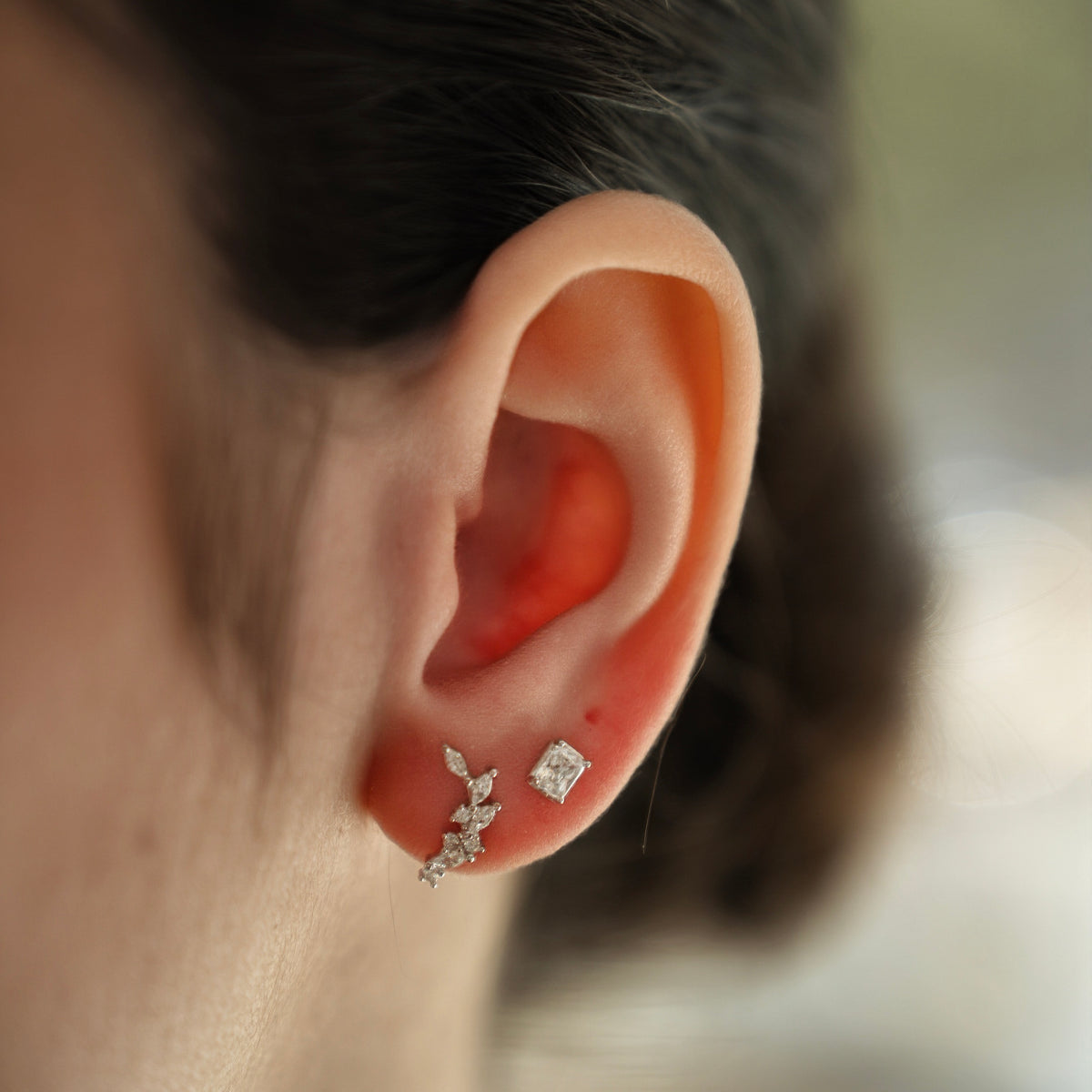 Rhodium-plated sterling silver stud earrings with marquise and round cubic zirconia leaf details on a light background
