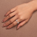 Rhodium-plated sterling silver open ring with marquise-cut clear stones arranged in floral motifs, worn on the finger