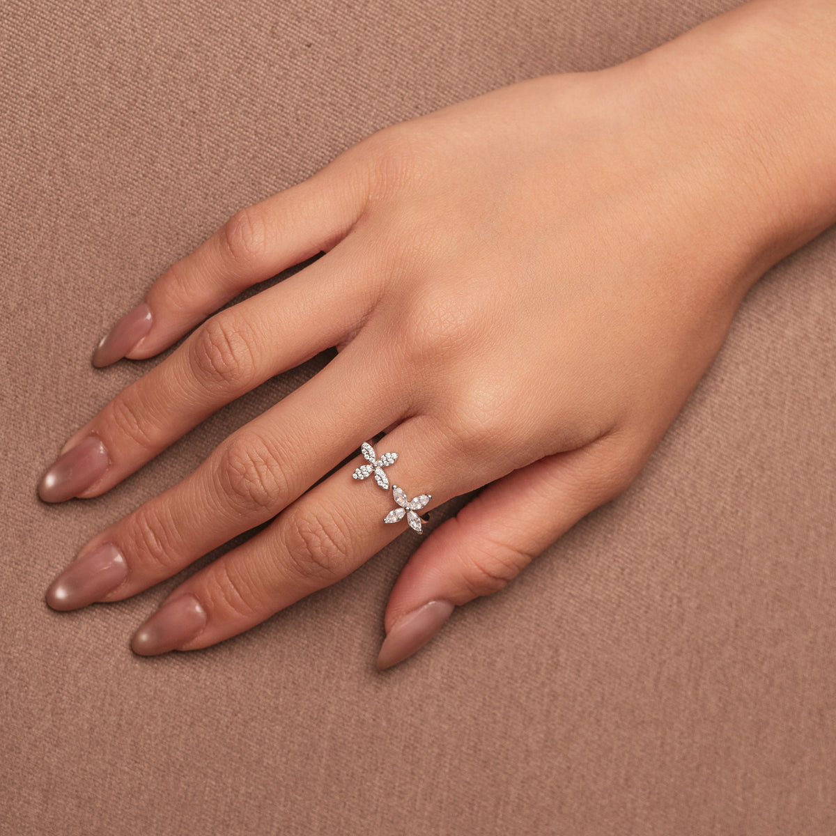 Rhodium-plated sterling silver open ring with marquise-cut clear stones arranged in floral motifs, worn on the finger