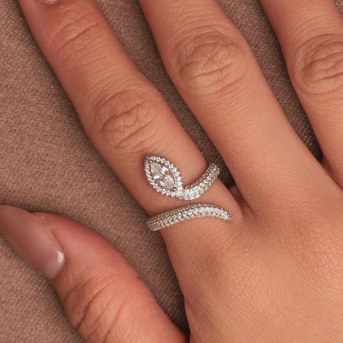 Rhodium-plated sterling silver snake wrap ring with clear cubic zirconia stones and a marquise-cut centerpiece worn on the finger