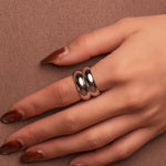Polished silver stainless steel chunky dome ring on a white background worn on finger
