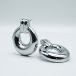 Polished silver stainless steel chunky link drop earrings on a light background