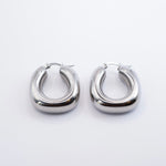 Polished silver stainless steel chunky rounded hoop earrings on a white background