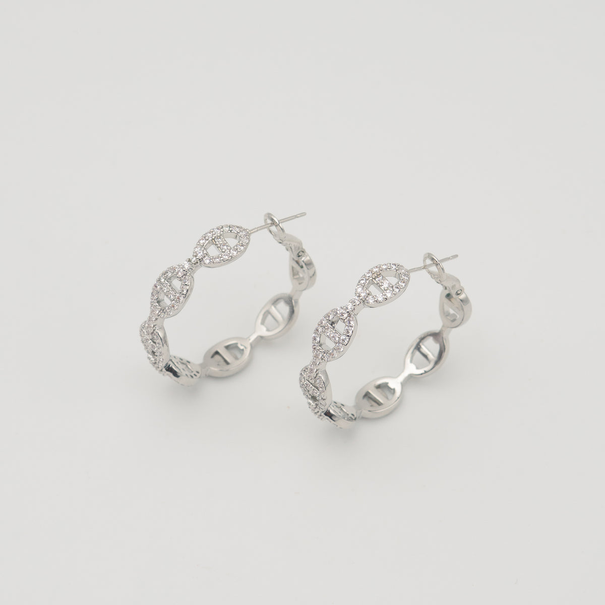 Silver stainless steel hoop earrings with pavé cubic zirconia oval link details 