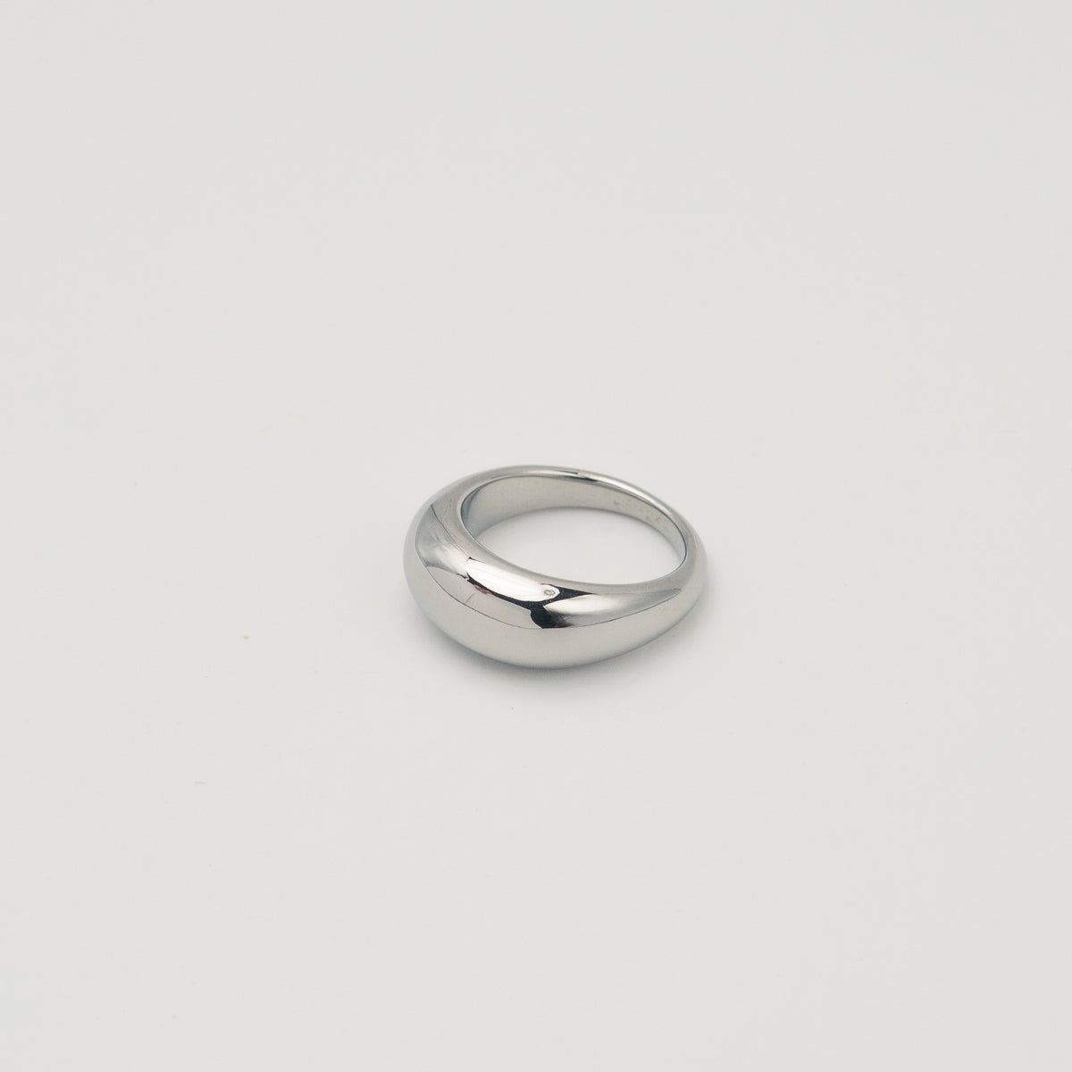 Polished silver stainless steel rounded band ring with a smooth dome profile on a light background