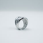 Polished silver stainless steel open ring with a chunky triple-band design on a light background