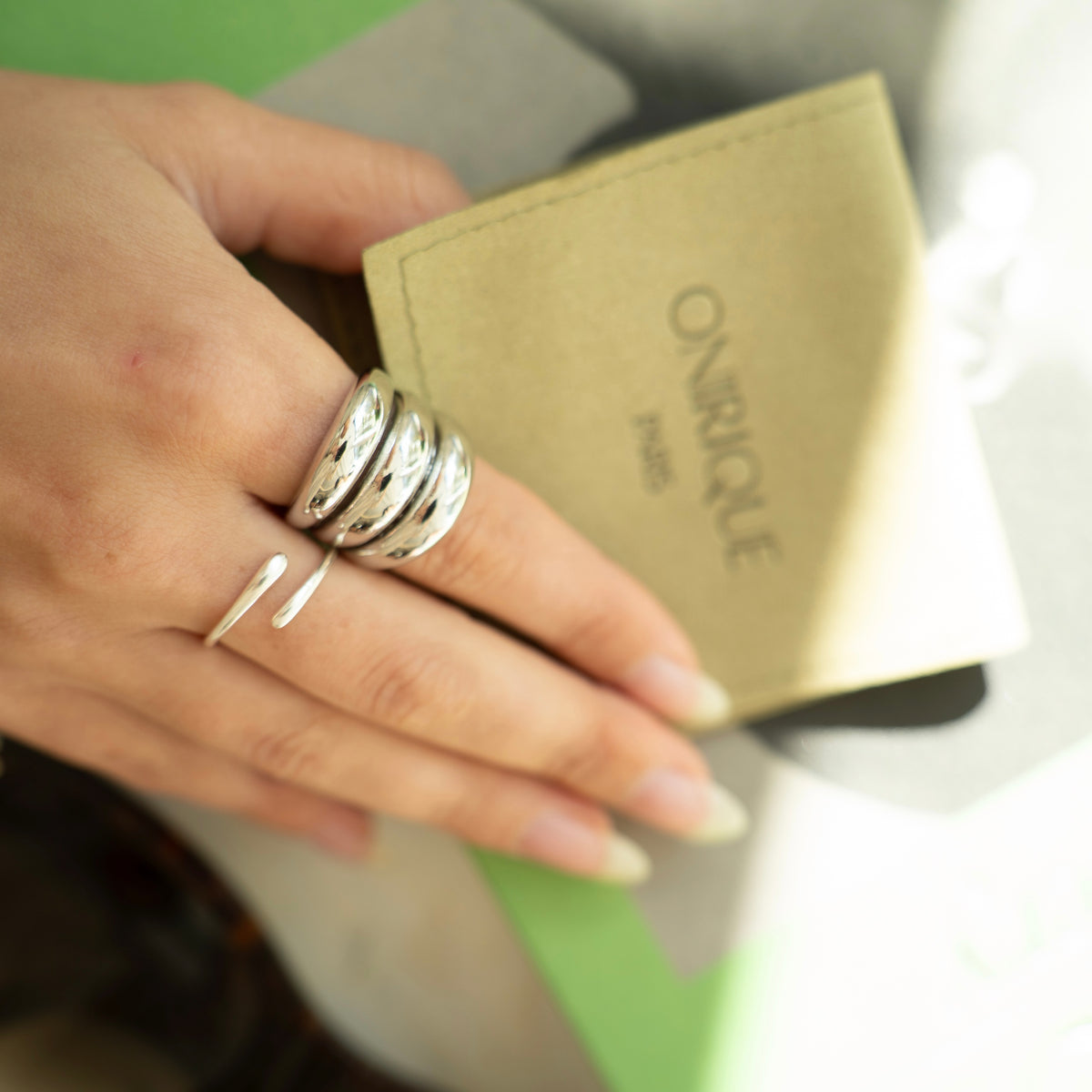 Polished silver stainless steel open ring with a chunky triple-band design worn on finger