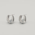 Polished silver stainless steel triple hoop earrings with a sculptural layered design