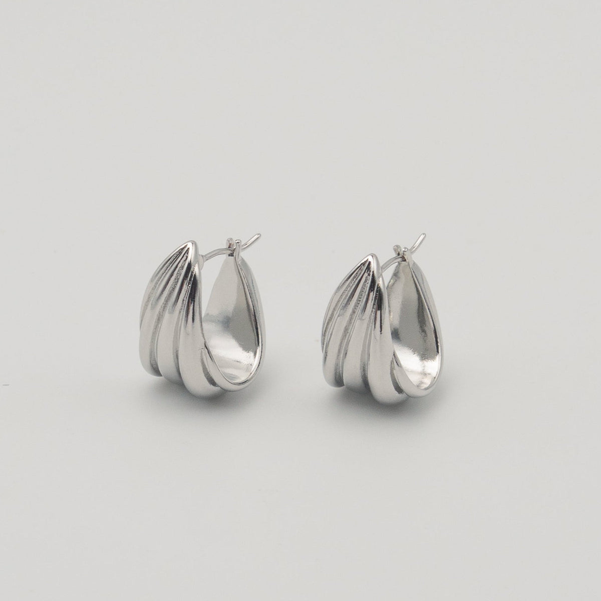 polished silver stainless steel triple hoop earrings with a sculptural layered design