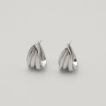 Polished silver stainless steel triple hoop earrings with a sculptural layered design