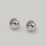 Polished sterling silver chunky clip earrings with a rounded dome shape on a light background