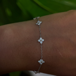 Sterling silver floral bracelet with clear cubic zirconia stones worn on the wrist.