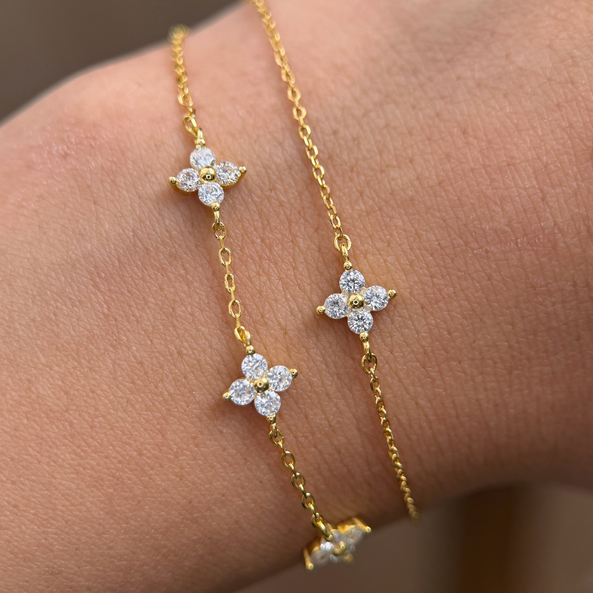 Gold-plated sterling silver flower bracelet with clear cubic zirconia stones.